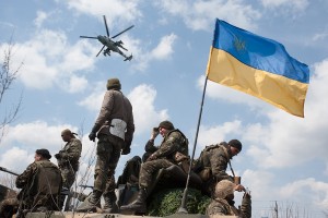 A military Ukrainian Army helicopter flies over a column of Ukrainian Army combat vehicles on the way to the town of Kramatorsk on Wednesday, April 16, 2014. The central government has so far been unable to rein in the insurgents, who it says are being stirred up by paid operatives from Russia and have seized numerous government facilities in at least nine eastern cities to press their demands for broader autonomy and closer ties with Russia. (AP Photo/ Evgeniy Maloletka)